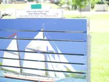 A painting in a park of a sailboat