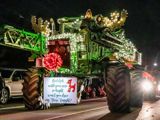 People on a tractor covered with Christmas lights