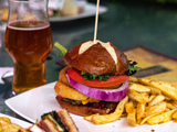 A burger, beer and sandwiches on a restaurant table 