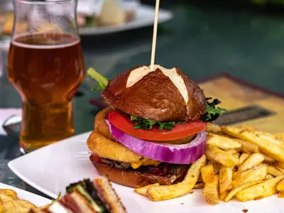 A burger, beer and sandwiches on a restaurant table
